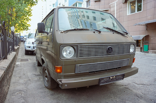 Almaty, Kazakhstan - August 17, 2023: The front part of the Volkswagen Transporter car is green. Street parking