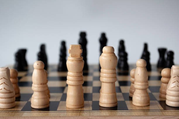 istock Battle between white and black chess on a chess boar. Strategy and tactics concept. 1735398263