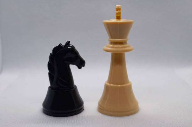 Pair of knights face off, lit from behind by a bright array of LEDs.