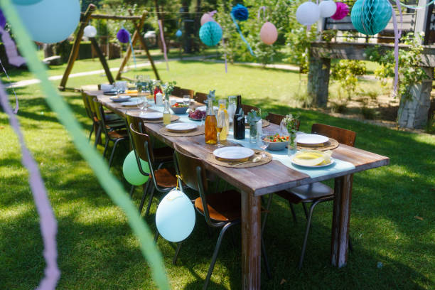 istock Set table for summer garden party. Table setting with glasses, fruit lemonade, fresh fruits and salads and delicate floral decoration. Colorful paper decorations for party. 1735399880