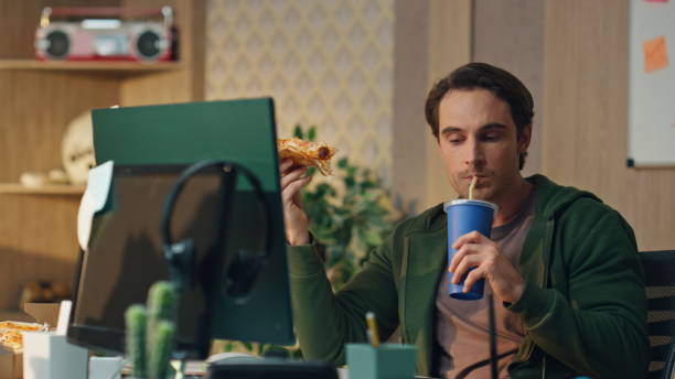 istock Hungry man drinking cola holding pizza office close up. Freelancer lunch break 1735401663