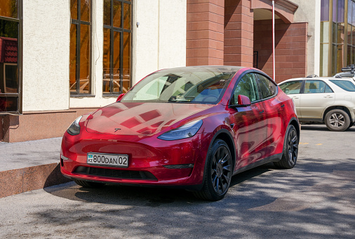 Almaty, Kazakhstan - August 25, 2023: The front clock of a Tesla Model 3 is red. Street parking