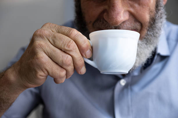 istock Old man drinking coffee with smile on his face 1735402020