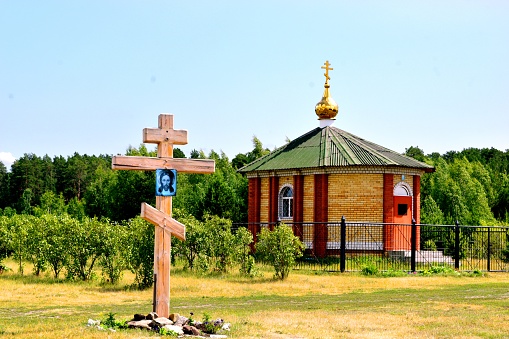 Orthodox chapel and cross of worship in the forest in the countryside against the background of nature.