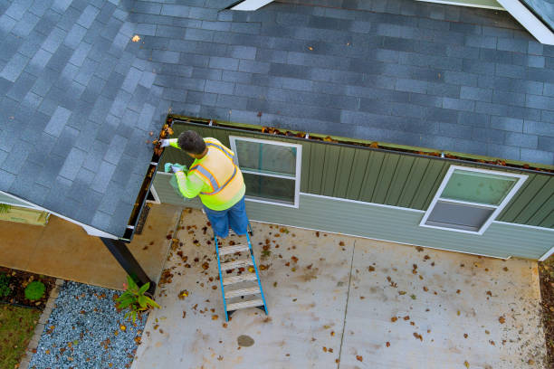 istock This worker is cleaning out clogged roof gutter drains that have become clogged with debris, fallen leaves 1735405667