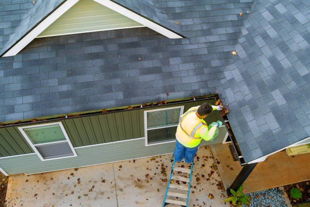 istock A worker is cleaning clogs in roof gutter drain by picking up dirt, debris, fallen leaves 1735405789
