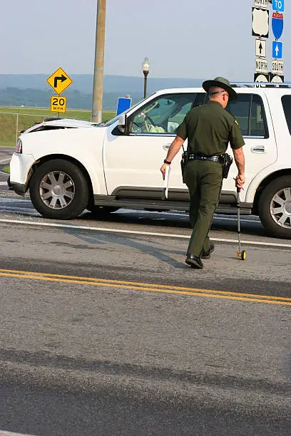 Photo of State Trooper Measuring Accident Scene