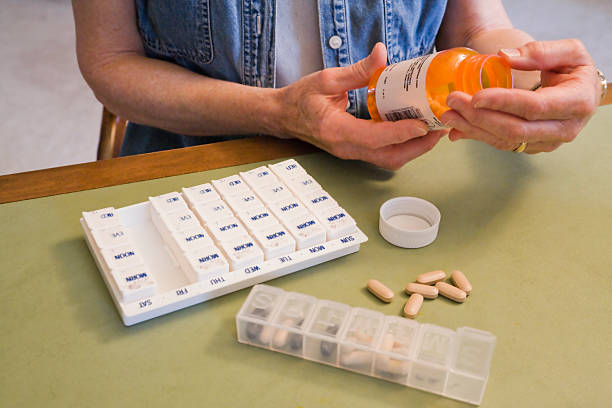 istock mature woman reading bottle and taking pills 173540592