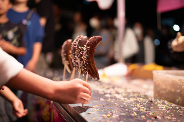 child's hand holding chocolate banana
