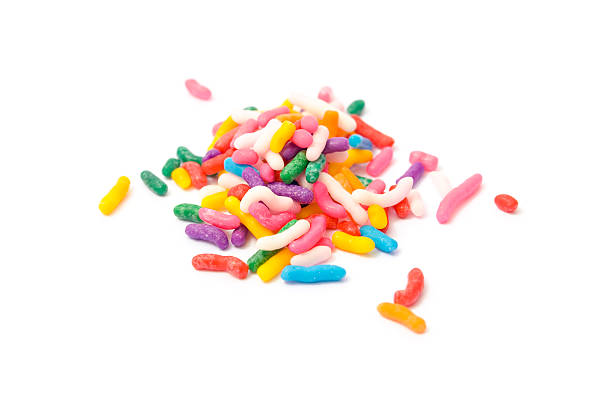 Small pile of rainbow sprinkles on white backdrop stock photo