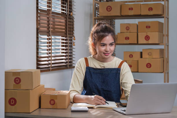 Portrait of Asian young woman SME working with a box at home the workplace.start-up small business owner, small business entrepreneur SME or freelance business online and delivery concept. Portrait of Asian young woman SME working with a box at home the workplace.start-up small business owner, small business entrepreneur SME or freelance business online and delivery concept. newspaper seller stock pictures, royalty-free photos & images