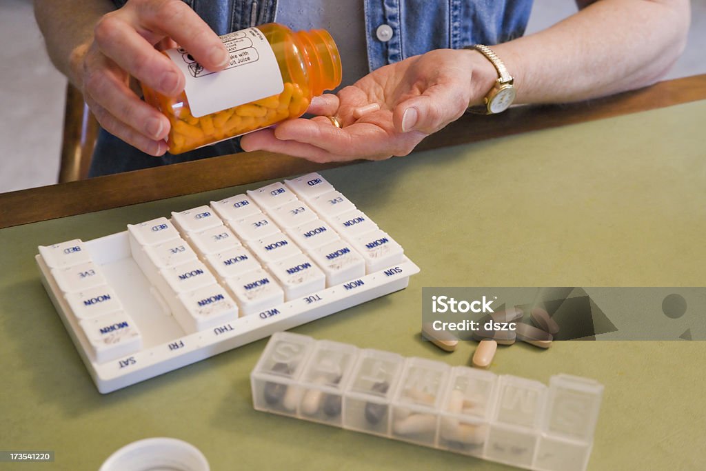Media edad mujer tomando píldoras - Foto de stock de Tercera edad libre de derechos