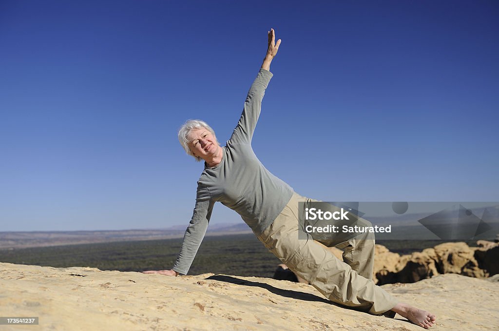 Senior practicar Pilates s'extiende en el desierto silvestre - Foto de stock de 60-64 años libre de derechos