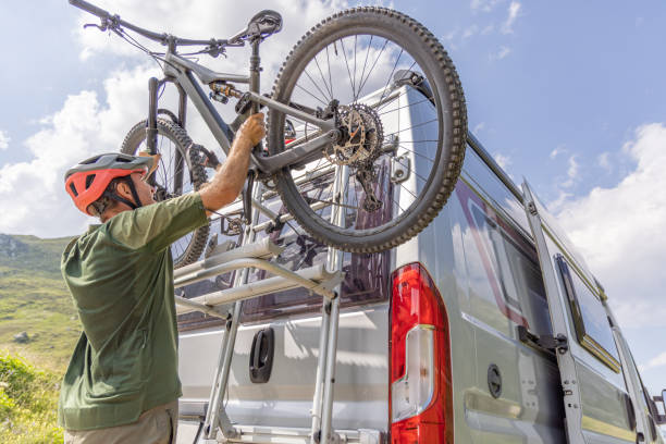 Mountain biker loads bike on camper van