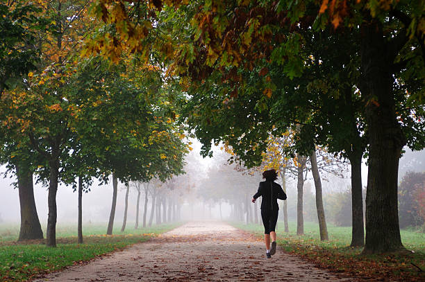 femme courir dans le brouillard - distance running jogging running fog photos et images de collection