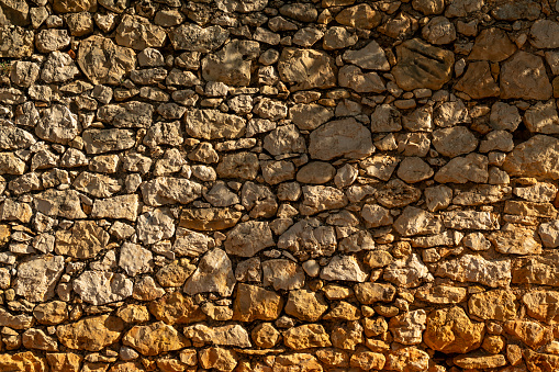 Old ancient stone facade wall of medieval brick horizontal stones background