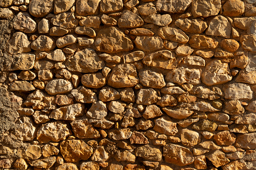 Frontal picture of a limestone wall in a mediterranean village - stock photo