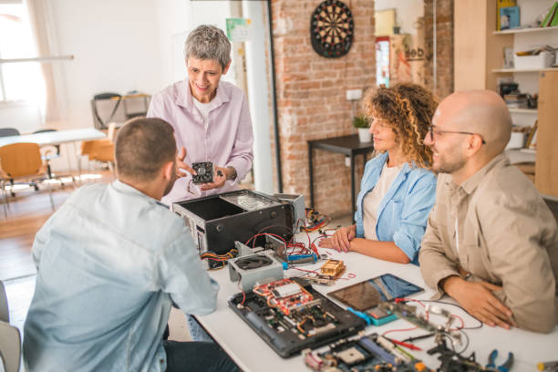 istock A female middle-aged electronics professor gives a group of students a lesson on computer hardware 1735414080