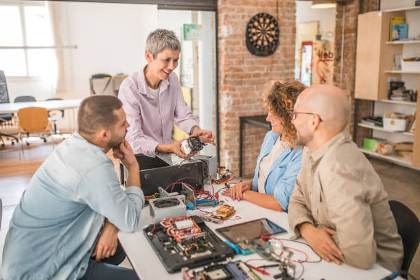 istock A happy middle-aged electronics professor gives a group of students a lesson on computer hardware 1735414254