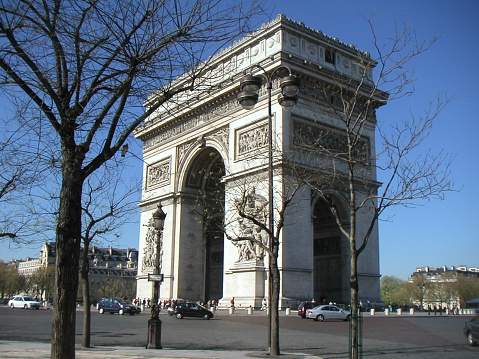 Arc de Triomphe in Paris France.  Photo taken on a clear sunny day.  Facing the monument generally westward.