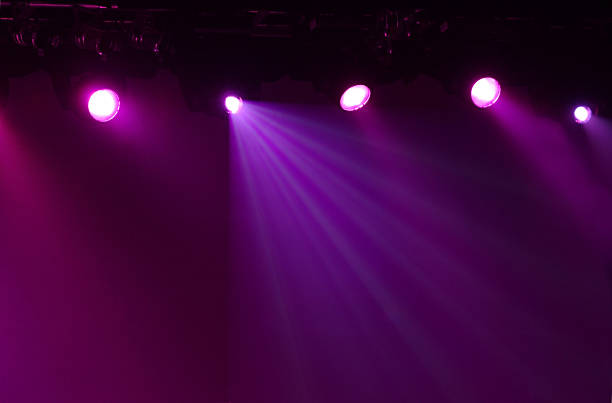 Glowing Purple Stage Lights with a Dark Background stock photo