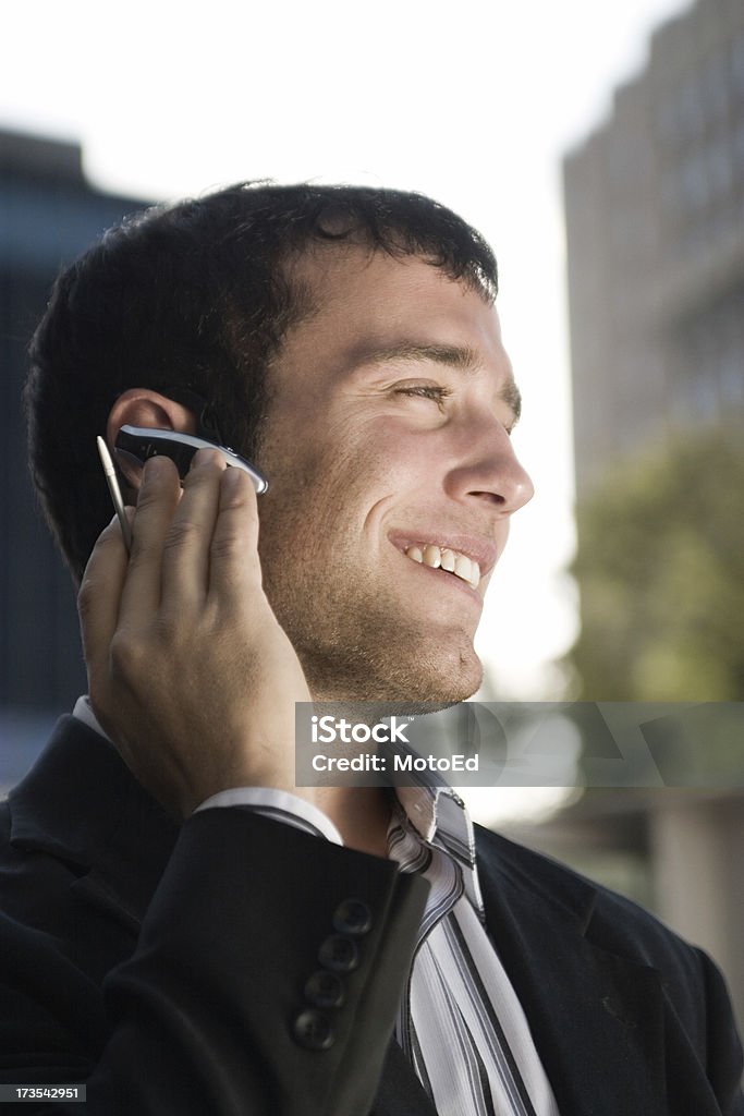 Businessman on a cell phone call Young businessman on a cell phone call with wireless headset. 20-24 Years Stock Photo