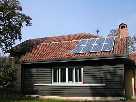 Solar panels on the house roof in sunny day. Renewable clean green energy generation.