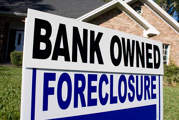 istock Foreclosure Yard Sign in front of a house 173543009