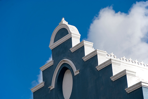 The roof of a tradional blue Bermuda church against a blue sky.