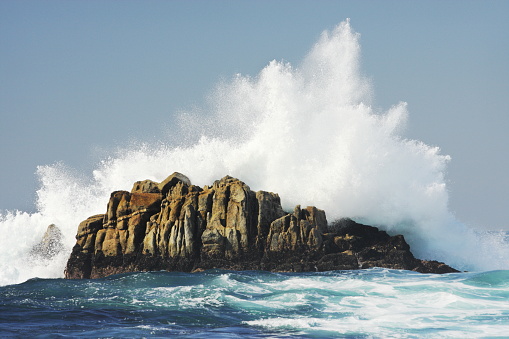 Ocean wave crashes rock coast with midair surf spray.  Pacific Grove, California, 2008.