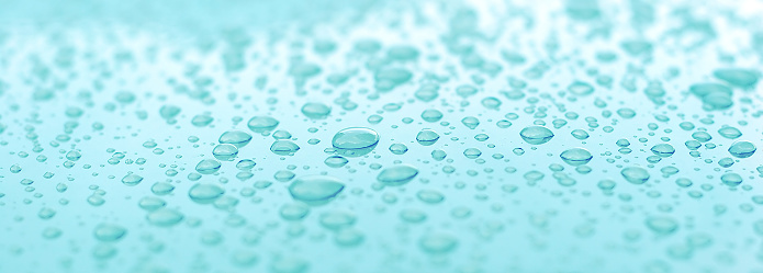 This is a picture of water droplets on an aqua surface.
