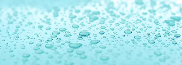 This is a picture of water droplets on an aqua surface.