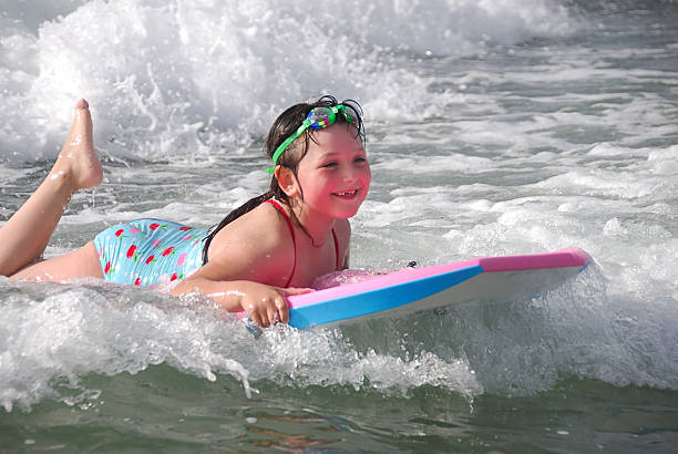 istock Summertime - Girl on Boggie Board Riding Waves 173545341