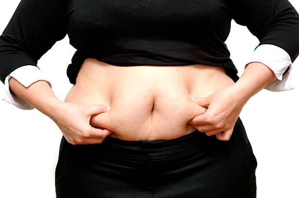 dieta, dieta i nadwaga dama trzymając żołądka - pot belly greed overweight excess zdjęcia i obrazy z banku zdjęć