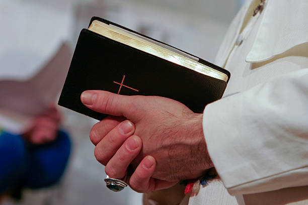 Man in popes garment holding holy bible stock photo