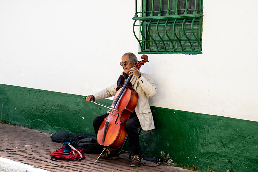 Bogota, Colombia - July 2nd 2023. Senior male musician performing on the streets of La Candelaria at the city center of Bogota
