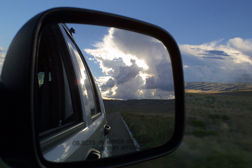 A brilliant cloud viewed through a car mirror.