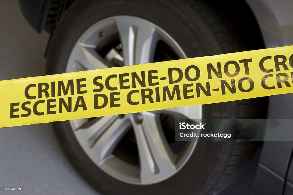 Crime Scene - Vehicle Police crime scene tape with a vehicle in the background. Barricade Tape Stock Photo