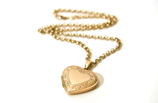 A gold locket on a chain. Shallow depth of field - focus on the locket.