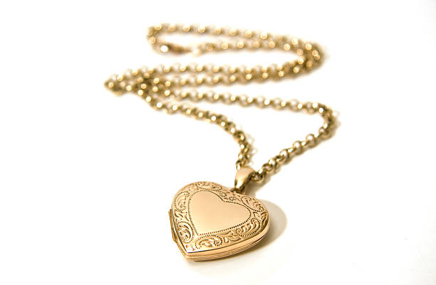 Gold Locket A gold locket on a chain. Shallow depth of field - focus on the locket. necklace stock pictures, royalty-free photos & images