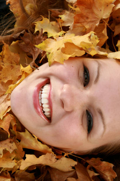 istock Woman Lying in Fall Leaves Smiling 173548633