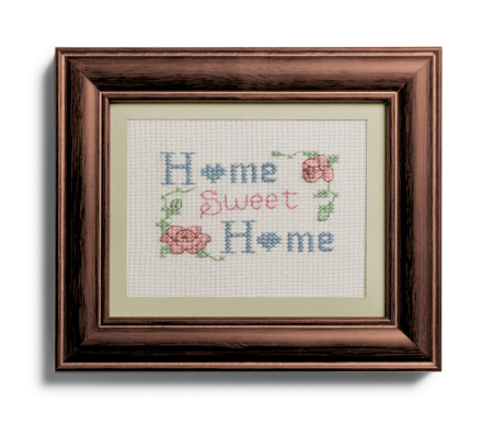 Hogar, dulce hogar muestreador en el marco sobre fondo blanco photo