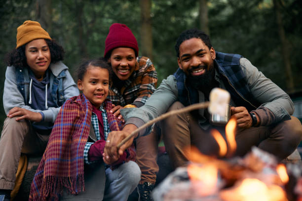 istock Happy black family roasting marshmallows on campfire at trailer park. 1735493103