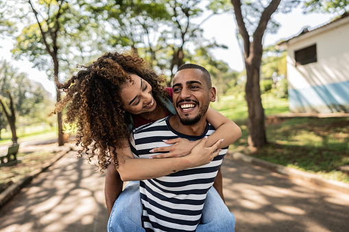 Young couple doing piggyback at a park