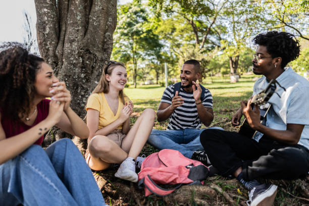 istock Student friends singing and playing guitar at university campus outdoors 1735501520