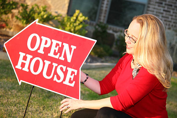 istock Real Estate Agent Setting up her Open House Sign 173550260