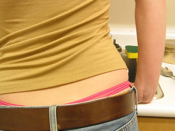 Rated R Kitchen Thong Image of female in kitchen with a pink thong, jeans, leather belt, rated r stock pictures, royalty-free photos & images