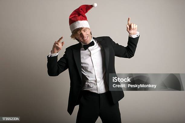 Man Celebrates Holidays Dancing In Santa Hat And Tuxedo Stock Photo - Download Image Now