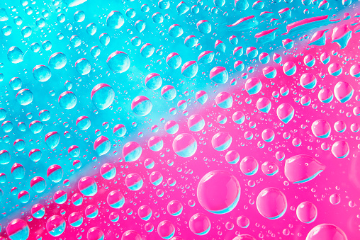 Water drops on blue and pink luminous background for background