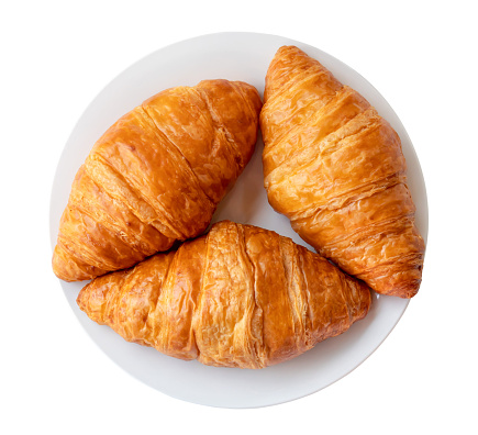 Appetizing croissants in white plate are isolated on white background with clipping path. Top view
